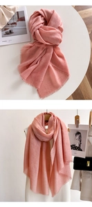 Detail of soft pink tassel scarf showing lightweight fabric texture and elegant fringe edge
