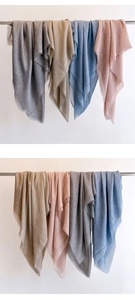 Detail of solid color summer shawls with fine fringe in grey, khaki, blue, and pink colors
