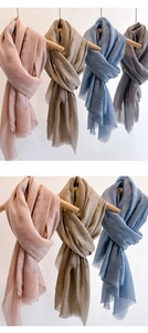 Detail of soft solid color scarves with delicate tassel edges in multiple pastel tones