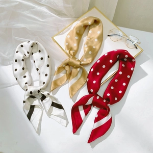 Détail de trois foulards en satin rayés en blanc, champagne et rouge élégants