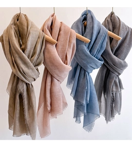 Close-up of lightweight solid color scarves with delicate tassel fringe in four natural tones