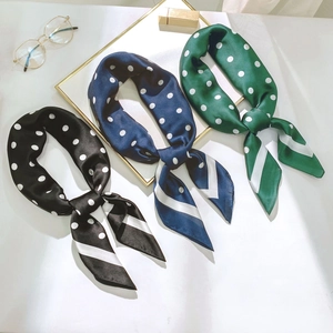 Détail de trois foulards en soie rayés noir, bleu et vert avec motifs à pois blancs