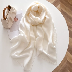 Detail of cream pashmina shawl with fine twill texture and short fringe edges
