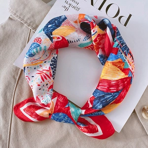 Détail d'un foulard en soie coloré avec imprimé floral abstrait sur fond neutre