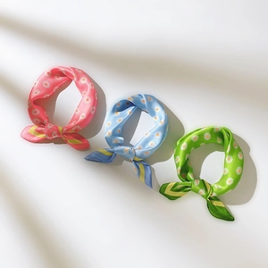 Vue détaillée de trois foulards en soie avec imprimé marguerites et fini satiné élégant