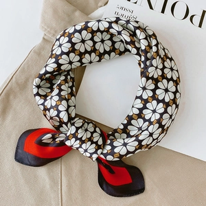 Détail d'un foulard en soie avec motifs floraux noirs et blocs rouges contrastés