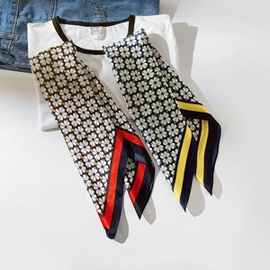 Détail de foulards en soie avec motifs trèfles sur fond de vêtements bleus et blancs