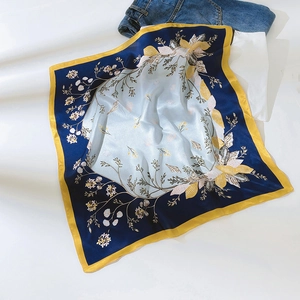 Vue détaillée d'un foulard en soie aux bordures bleu marine et jaune gingembre élégantes