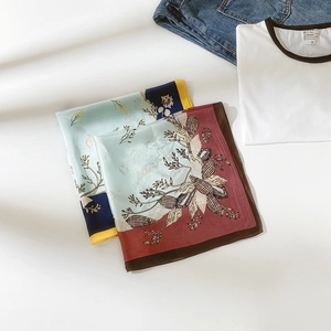 Détail de foulards en soie élégants avec imprimés floraux et coquillages bleu et bordeaux