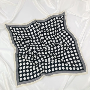 Detailed view of polka dot silk scarf with striped borders and elegant satin finish