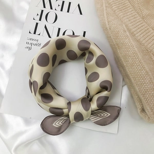 Close-up of silk-textured polka dot scarf with fine rolled edges on white background