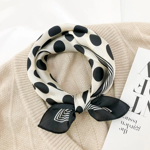 Detailed view of silk satin scarf with polka dots over a warm knitted sweater