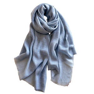 Light blue linen shawl scarf with fine fringe trim and breathable texture on white background