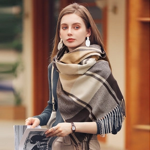 Detail of warm earth-tone plaid scarf with soft fringe and premium twill texture