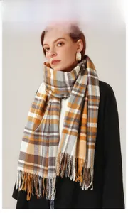 Close-up of yellow and grey plaid scarf with soft fringe tassels for winter warmth
