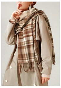 Detail of classic brown plaid scarf featuring soft cashmere texture and long fringe trim