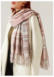 Detail of pink and grey plaid scarf with long tassels and soft knit texture close-up