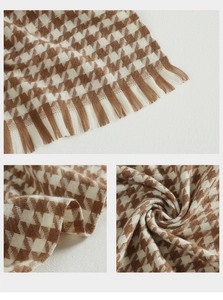 Detail of classic houndstooth scarf showing soft fringes and thick cashmere-like texture