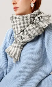 Detailansicht eines grau-weißen Hahnentrittmusterschals mit weichen Fransen und Stricktextur