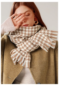 Detail of classic camel and cream houndstooth scarf with natural soft fringe texture