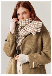 Close-up of brown houndstooth scarf paired with a wool coat showing fringe and fabric detail