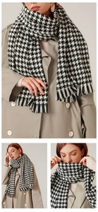 Detail of classic black and white houndstooth scarf with elegant tassel fringe finish