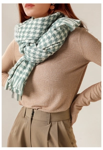 Close-up of green houndstooth scarf with tassels on a model for winter fashion