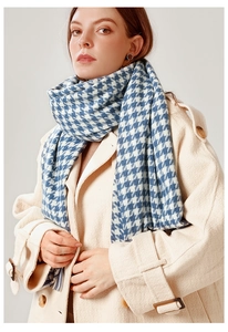 Close-up of thick blue and white houndstooth scarf texture worn with a beige wool coat
