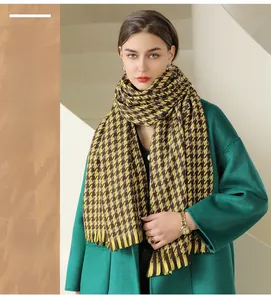 Detail of yellow houndstooth pattern scarf with fringe edges and soft knit texture