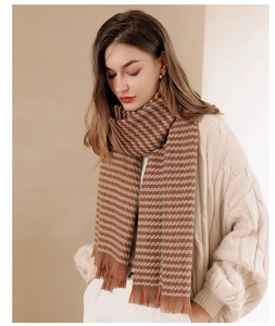 Close-up of brown and beige houndstooth scarf with soft fringed edges on model