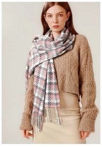 Détail de l'écharpe à carreaux rose et gris avec franges sur un pull en maille