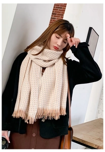 Détail d'une écharpe d'hiver à motifs géométriques orange avec des finitions à franges