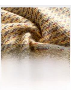 Détail macro de l'écharpe à carreaux montrant la texture douce et le tissage multicolore