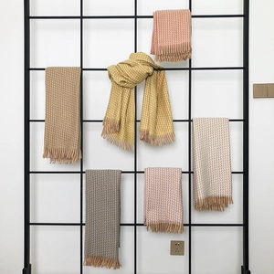 Détail d'écharpes à carreaux multicolores avec franges fines sur un support