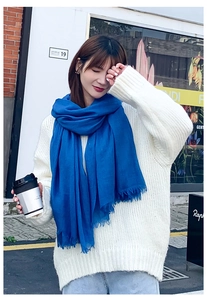 Détail d'une écharpe en lin bleu roi avec de fines franges portée par un mannequin