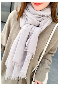 Détail d'une écharpe en coton et lin violet clair avec de fines franges sur un mannequin