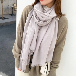 Écharpe élégante en coton et lin gris clair avec franges douces portée par un mannequin