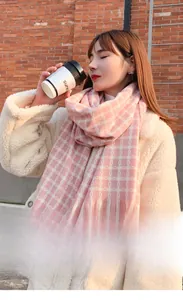 Close-up of pink and white checkered cashmere-like scarf with fringe details in winter