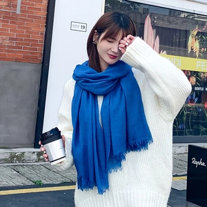 Écharpe bleu Klein en coton et lin avec franges sur un pull en maille blanc chic