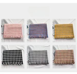 Detail view of winter knitted fringe scarves showing six classic plaid color options