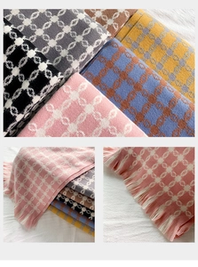 Detail of soft winter shawl with geometric chain pattern and stylish tassel edges