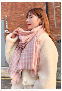 Detail of pink and white plaid cashmere scarf with soft tassels on winter coat