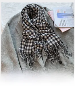 Detailed view of black and white plaid scarf texture with soft fringe edges and tassels