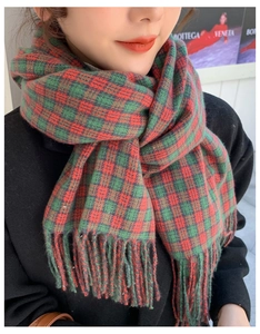 Detail of red and green plaid winter scarf texture and soft tassel fringe edges