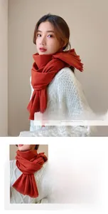 Detail of warm rust red cashmere-feel thick scarf with soft frayed edge for winter
