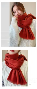 Detail of soft brick red winter scarf featuring fringe edges and cashmere-like texture