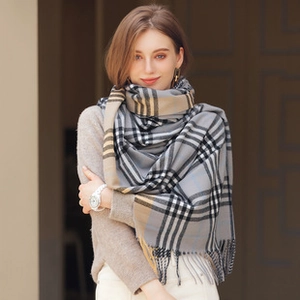 Detailed view of grey checkered scarf texture with elegant tassels and fringe