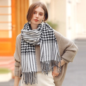 Detailed view of black and white houndstooth knit scarf with elegant fringe trim edges