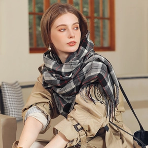 Detailed view of the classic plaid texture and soft fringe on the winter cashmere scarf