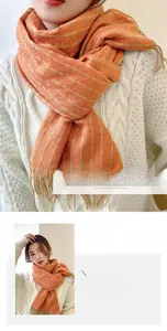 Close-up of thick rust red knit scarf with fringe tassels and soft geometric textures